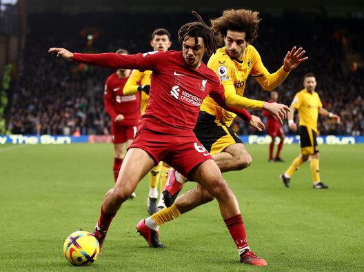 WOLVERHAMPTON, ENGLAND - FEBRUARY 04: Trent Alexander-Arnold of Liverpool battles for the ball with Rayan Ait-Nouri of Wolverhampton Wanderers during the Premier League match between Wolverhampton Wanderers and Liverpool FC at Molineux on February 04, 2023 in Wolverhampton, England. In a Premier League first, both sets of players, and match officials, will wear Green Football Weekend sustainable green armbands to highlight the initiative and put the conversation about climate change and sustainability on the world stage. (Photo by Naomi Baker/Getty Images)(Photo by Naomi Baker/Getty Images)  Liverpool
