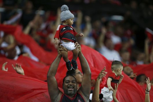 RIO DE JANEIRO, BRASILE - 8 NOVEMBRE: Un fan del Flamengo tiene in braccio un bambino durante la partita tra Flamengo e Palmeiras come parte del Brasileirao 2023 allo Stadio Maracana l'8 novembre 2023 a Rio de Janeiro, Brasile. (Foto di Wagner Meier/Getty Images) Flamengo – Chelsea: coreografie, cori e tifosi. Due mondi, una fede- immagine 3