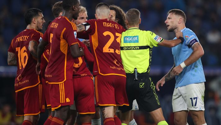 ROME, ITALY - NOVEMBER 12: Ciro Immobile of SS Lazio is separated from AS Roma players by referee Davide Massa during the Serie A TIM match between SS Lazio and AS Roma at Stadio Olimpico on November 12, 2023 in Rome, Italy. (Photo by Paolo Bruno/Getty Images) Lazio e Roma nervose sul campo nel derby