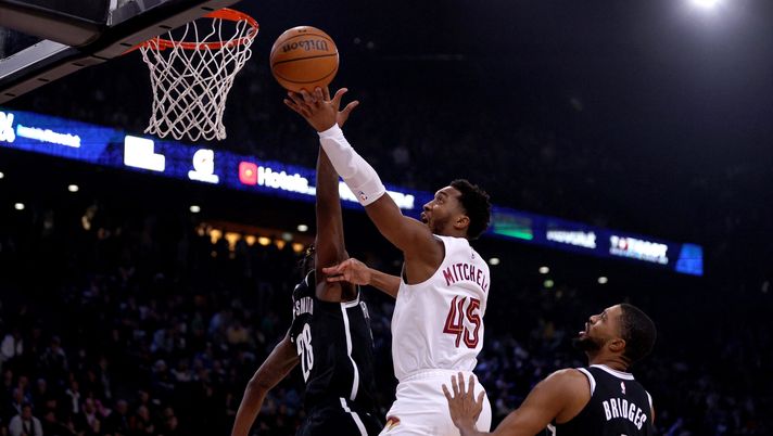 PARIS, FRANCE - JANUARY 11: Donovan Mitchell of Cleveland Cavaliers scores against Dorian Finney-Smiath and Mikal Bridges of Brooklyn Nets during the NBA match between Brooklyn Nets and Cleveland Cavaliers at The Accor Arena on January 11, 2024 in Paris, France. (Photo by Dean Mouhtaropoulos/Getty Images) Cavs-Blazers, dove vedere la partita in diretta tv e in streaming LIVE - immagine 1
