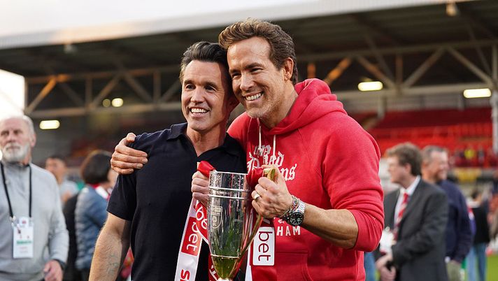 WREXHAM, WALES - APRIL 26: Rob McElhenney and Ryan Reynolds, co-owners of Wrexham AFC, pose for a photo with the trophy following the club's promotion to the Sky Bet Championship during the Sky Bet League One match between Wrexham AFC and Charlton Athletic FC at Racecourse Ground on April 26, 2025 in Wrexham, Wales. (Photo by Kya Banasko/Getty Images) Wrexham, nuova stagione della docuserie in arrivo: ecco quando uscirà - immagine 1