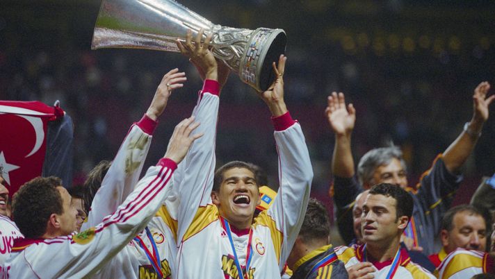 Brazilian footballer Capone raises the trophy aloft as he celebrates with his Galatasaray teammates after the UEFA Cup Final, between Galatasaray and Arsenal, at the Parken Stadium in Copenhagen, Denmark, 17th May 2000. The match ended 0-0 with Galatasaray winning 4-1 on penalties. (Photo by Lutz Bongarts/Bongarts/Getty Images) Gol, rimonte e drammi: ecco le finali più epiche dell’Europa League - immagine 1