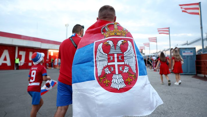 BELGRADE, SERBIA - SEPTEMBER 09: A fan walks to the stadium wearing a flag with a Serbian flag on it prior to the FIFA World Cup 2026 qualifier match between Serbia and England at Rajko Mitic Stadium on September 09, 2025 in Belgrade, Serbia. (Photo by Michael Regan/Getty Images) La Serbia teme nuovi scontri tra tifosi: nessun biglietto per la trasferta in Inghilterra - immagine 1