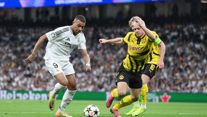 MADRID, SPAIN - OCTOBER 22: Kylian Mbappe of Real Madrid runs with the ball whilst under pressure from Julian Ryerson of Borussia Dortmund during the UEFA Champions League 2024/25 League Phase MD3 match between Real Madrid C.F. and Borussia Dortmund at Estadio Santiago Bernabeu on October 22, 2024 in Madrid, Spain. (Photo by David Ramos/Getty Images) Real Madrid-Dortmund 3-2, un anno dopo Wembley: il tempo stravolge le squadre, non la sentenza - immagine 1