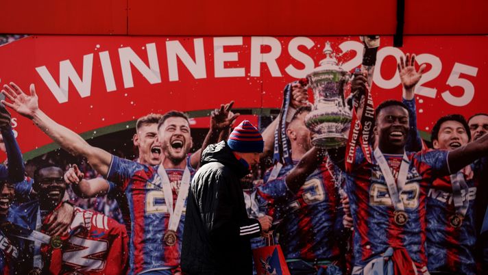 Un tifoso del Crystal Palace passa davanti a un'immagine appesa al muro che ritrae i giocatori del Crystal Palace mentre sollevano la FA Cup 2025, prima della partita di Premier League tra Crystal Palace e Leeds United al Selhurst Park di Londra, Inghilterra, il 15 marzo 2026. (Foto di Justin Setterfield/Getty Images)
Crystal Palace Selhurst Park