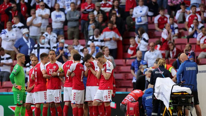 COPENHAGEN, DENMARK - JUNE 12: Players of Denmark stand dejected as Christian Eriksen (Hidden) of Denmark receives medical treatment during the UEFA Euro 2020 Championship Group B match between Denmark and Finland on June 12, 2021 in Copenhagen, Denmark. (Photo by Friedemann Vogel - Pool/Getty Images) Danimarca, l’immagine fa il giro del mondo: Eriksen protetto dai suoi compagni - immagine 1