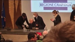 De Luca che combini! Gli spostano la sedia e lui cade a terra. Poi si rialza subito