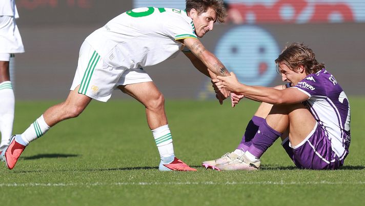 FLORENCE, ITALY - OCTOBER 5: Tommaso Baldanzi of AS Roma helps Jacopo Fazzini of ACF Fiorentina to his feet during the Serie A match between ACF Fiorentina and AS Roma at Artemio Franchi on October 5, 2025 in Florence, Italy. (Photo by Gabriele Maltinti/Getty Images) Fazzini ko: prima stringe i denti, poi chiede il cambio. Le sue condizioni - immagine 1