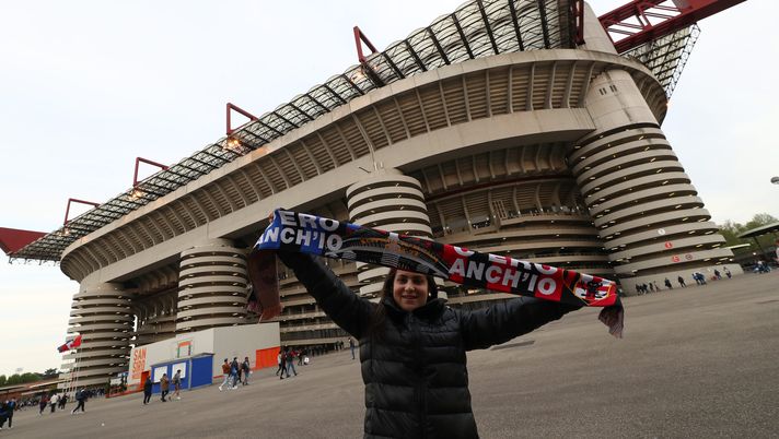 MILAN, ITALY - APRIL 19: A fan poses for a photograph with a half and half scarf outside the Giuseppe Meazza Stadium prior to kick off of the Coppa Italia Semi Final 2nd Leg match between FC Internazionale v AC Milan at Giuseppe Meazza Stadium on April 19, 2022 in Milan, Italy. (Photo by Marco Luzzani/Getty Images) Dal 1970 a oggi, i derby e le serie positive: i filotti del Milan e quelli dell’Inter - immagine 1