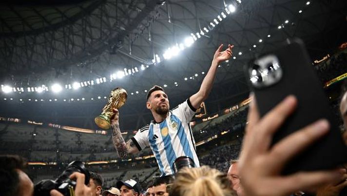 Argentina's captain and forward #10 Lionel Messi (R) holds the FIFA World Cup Trophy following the trophy ceremony after Argentina won the Qatar 2022 World Cup final football match between Argentina and France at Lusail Stadium in Lusail, north of Doha on December 18, 2022. (Photo by Anne-Christine POUJOULAT / AFP) (Photo by ANNE-CHRISTINE POUJOULAT/AFP via Getty Images) All’asta le maglie del mondiale di Messi: si parte da 10 milioni di dollari - immagine 1