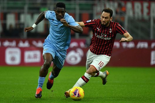 MILANO, ITALIA - 3 NOVEMBRE: Quissanga Bastos della Lazio si contende il pallone con Hakan Calhanoglu durante la partita di Serie A tra Milan e Lazio allo Stadio Giuseppe Meazza il 3 novembre 2019 a Milano, Italia. (Foto di Marco Rosi/Getty Images) Calhanoglu