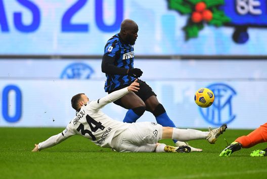 MILAN, ITALY - DECEMBER 20: Romelu Lukaku of FC Internazionale competes for the ball with Ardian Ismajli of Spezia Calcio during the Serie A match between FC Internazionale and Spezia Calcio at Stadio Giuseppe Meazza on December 20, 2020 in Milan, Italy. Sporting stadiums around Italy remain under strict restrictions due to the Coronavirus Pandemic as Government social distancing laws prohibit fans inside venues resulting in games being played behind closed doors. (Photo by Claudio Villa - Inter/Inter via Getty Images)