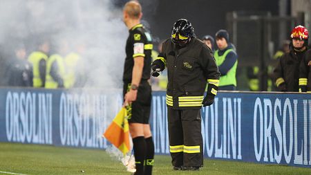ROME, ITALY - JANUARY 10: A fire marshall removes a flare thrown onto the pitch prior to the Coppa Italia match between SS Lazio and AS Roma at Stadio Olimpico on January 10, 2024 in Rome, Italy. (Photo by Paolo Bruno/Getty Images)