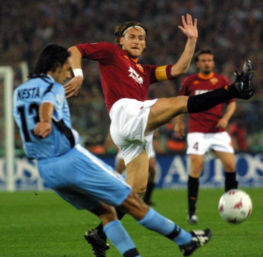 Il capitano della Lazio Alessandro Nesta (al centro) lotta per la palla con il capitano della Roma Francesco Totti durante il derby d'esordio del campionato italiano di calcio, allo Stadio Olimpico di Roma, il 29 aprile 2001 ESCLUSIVA, Lima su Lazio-Roma: “Dovbyk non perdona, Konè può fare la differenza”- immagine 2
