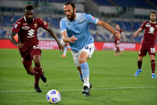 ROME, ITALY - MAY 18: Vedat Muriqi of SS Lazio compete for the ball with Nicolas Nkoulou of Torino FC during the Serie A match between SS Lazio and Torino FC at Stadio Olimpico on May 18, 2021 in Rome, Italy. The match, despite it's not postponed by Lega Serie A, will not be played as Torino team need to observe a home quarantine until midnight on Tuesday due to Covd-19. (Photo by Marco Rosi - SS Lazio/Getty Images)