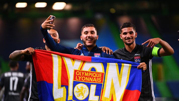 LISBON, PORTUGAL - AUGUST 15: Memphis Depay, Rayan Cherki and Houssem Aouar of Olympique Lyon celebrate with a supporters flag following their team's victory in the UEFA Champions League Quarter Final match between Manchester City and Lyon at Estadio Jose Alvalade on August 15, 2020 in Lisbon, Portugal. (Photo by Franck Fife/Pool via Getty Images) Cherki