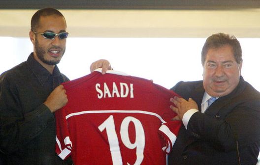 Saadi Gheddafi (a sinistra), figlio del leader libico Muammar Gheddafi, mostra la sua nuova maglia del Perugia insieme al presidente Luciano Gaucci. Presentazione ufficiale di Gheddafi a Torre Alfina, il 29 giugno 2003 Caos Serie B: dal 2002 ad oggi, quando la burocrazia riscrive le classifiche- immagine 4