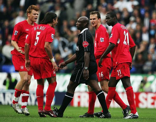 Uriah Rennie, arbitro circondato dai giocatori del Liverpool in una partita di Premier League. (Foto di Laurence Griffiths/Getty Images) Morto in Inghilterra il primo arbitro nero della storia della Premier League- immagine 2