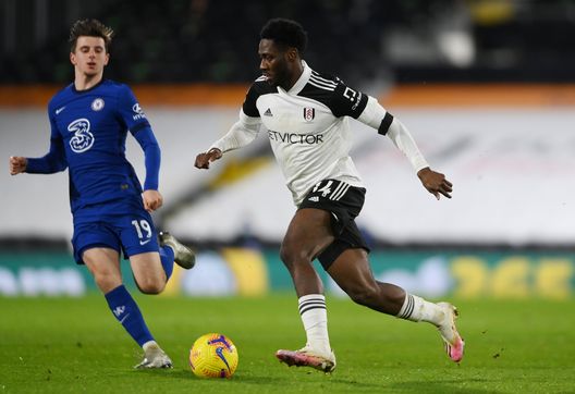 LONDON, ENGLAND - JANUARY 16: Ola Aina of Fulham runs with the ball under pressure from Mason Mount of Chelsea during the Premier League match between Fulham and Chelsea at Craven Cottage on January 16, 2021 in London, England. Sporting stadiums around England remain under strict restrictions due to the Coronavirus Pandemic as Government social distancing laws prohibit fans inside venues resulting in games being played behind closed doors. (Photo by Mike Hewitt/Getty Images)