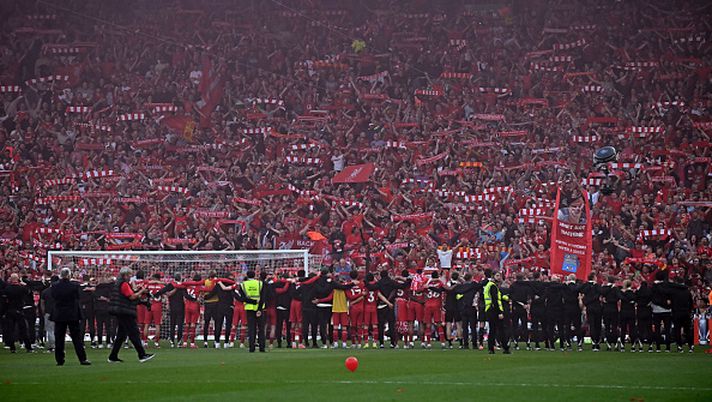 I giocatori festeggiano davanti ai tifosi del Liverpool dopo la partita di Premier League tra Liverpool e Tottenham Hotspur ad Anfield, Liverpool, nel nord-ovest dell'Inghilterra, il 27 aprile 2025. Il Liverpool è stato incoronato campione d'Inghilterra per la ventesima volta, eguagliando un record, grazie alla vittoria per 5-1 sul Tottenham domenica, che ha sancito il suo primo titolo di Premier League dal 2020. (Foto di Paul ELLIS / AFP) Liverpool