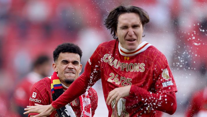 LIVERPOOL, ENGLAND - APRIL 27: Luis Diaz of Liverpool sprays drink over Federico Chiesa of Liverpool, as he celebrates the teams victory and confirmation of winning the Premier League title after the Premier League match between Liverpool FC and Tottenham Hotspur FC at Anfield on April 27, 2025 in Liverpool, England. (Photo by Carl Recine/Getty Images) Liverpool, bottino da record per la vittoria della Premier League: ecco quanto - immagine 1