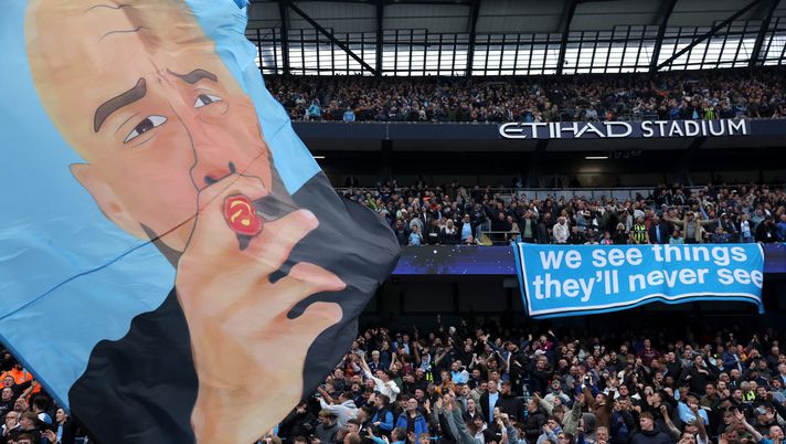 MANCHESTER, ENGLAND - SEPTEMBER 22: Fans hold up a banner in support of Josep Guardiola, Manager of Manchester City, and a banner reading 'we see things they'll never see' during the Premier League match between Manchester City FC and Arsenal FC at Etihad Stadium on September 22, 2024 in Manchester, England. (Photo by Carl Recine/Getty Images) Manchester City nella bufera: azione legale dei tifosi contro gli abbonamenti - immagine 1