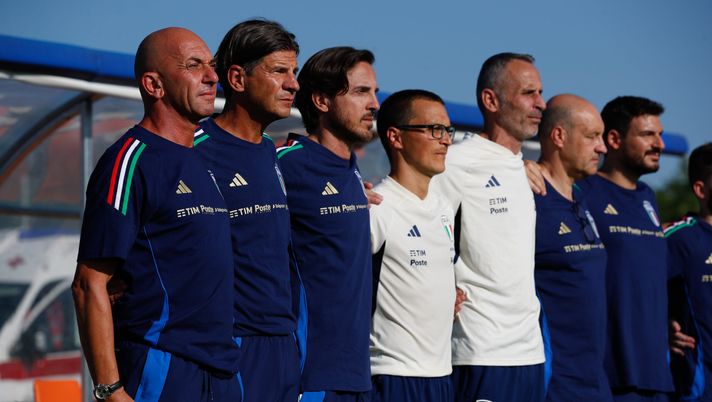 MANZANO, ITALY - AUGUST 06: Head Coach of Italy Alberto Bollini (L) with his staff during the national anthems at the International Friendly match between Italy U19 and Slovenia U19 at Stadio Comunale Giuseppe Morigi on August 06, 2024 in Manzano, Italy. (Photo by Timothy Rogers/Getty Images) Nazionale U19, i convocati per lo stage: la prima volta per un baby viola - immagine 1