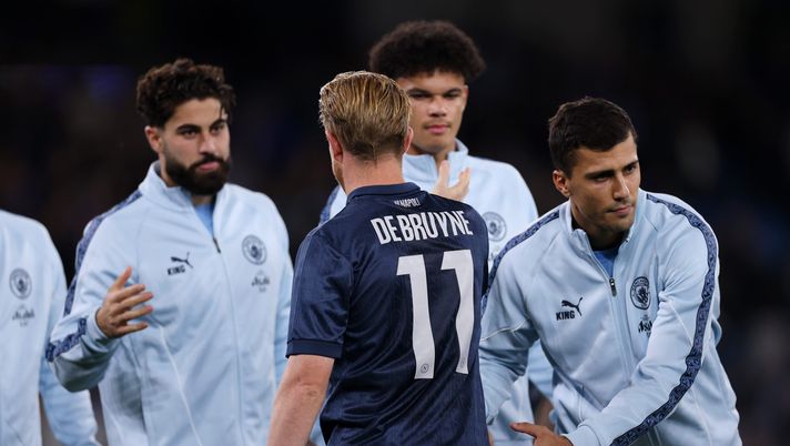 MANCHESTER, ENGLAND - SEPTEMBER 18: Kevin De Bruyne of Napoli is embraced by Rodri of Manchester City prior to the UEFA Champions League 2025/26 League Phase MD1 match between Manchester City and SSC Napoli at City of Manchester Stadium on September 18, 2025 in Manchester, England. (Photo by Ryan Pierse/Getty Images) De Bruyne torna a Manchester, che accoglienza! Cori e striscioni per lui – FOTO - immagine 1