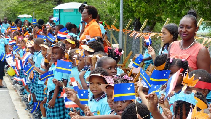 CURACAO, NETHERLANDS ANTILLES - NOVEMBER 19: Children wait to greet King Willem-Alexander of the Netherlands and Queen Maxima of the Netherlands during their visit on November 19, 2013 in Curacao, Netherlands Antilles. King Willem-Alexander and Queen Maxima are on a ten day visit to the six islands which constitute the Caribbean part of the kingdom of the Netherlands. (Photo by Getty Images) La favola Curaçao, il Paese che sogna il Mondiale con una squadra completamente “europea” - immagine 1