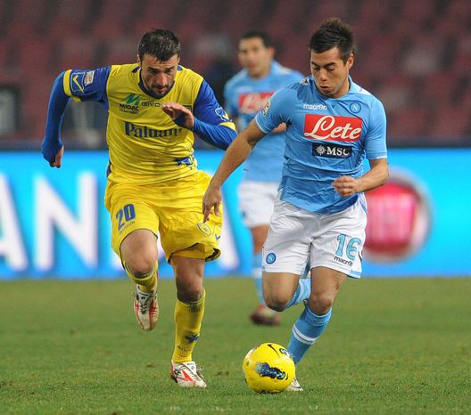 NAPLES, ITALY - FEBRUARY 13: Gennaro Sardo (L) of Chievo Verona looks to challenge Edu Vargas of Napoli during the Serie A match between SSC Napoli and AC Chievo Verona at Stadio San Paolo on February 13, 2012 in Naples, Italy. (Photo by Giuseppe Bellini/Getty Images)