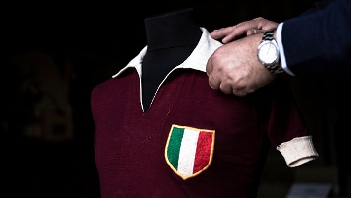 Volunteer Vito Mazzilli adjusts the jersey of Grande Torino's football player Ezio Loik in the Museum of Grande Torino and Granata's legend in Grugliasco, near Turin, on April 23, 2019. - Every year thousands gather at the Basilica of Superga overlooking Turin to commemorate the memory of Italian football's all-conquering 'Grande Torino' team who were wiped out in an air disaster. This year, Englishman Bill Lievesley will be among them to mark the 70th anniversary of the tragedy which claimed the lives of 31 people including his father Leslie Lievesley, the team coach, among 18 players and officials. (Photo by MARCO BERTORELLO / AFP) (Photo credit should read MARCO BERTORELLO/AFP via Getty Images) 4 maggio 1949, l’aereo del Grande Torino si schianta a Superga: calcio in lutto - immagine 1