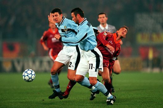 Francesco Totti (a destra) della Roma viene fermato sul suo cammino da Paolo Negro (a sinistra) e Sinisa Mihajlovic (al centro) della Lazio “Capitano mio capitano”: i capitani storici del derby Lazio-Roma- immagine 4