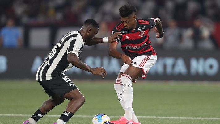 RIO DE JANEIRO, BRAZIL - AUGUST 18: Bastos Quissanga of Botafogo fights for the ball with Bruno Henrique of Flamengo during the match between Botafogo and Flamengo as part of Brasileirao 2024 at Estadio Olimpico Nilton Santos on August 18, 2024 in Rio de Janeiro, Brazil. (Photo by Wagner Meier/Getty Images) Dal canottaggio al Maracanà: la storia di Flamengo-Botafogo - immagine 1