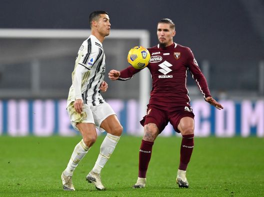 TURIN, ITALY - DECEMBER 05: Cristiano Ronaldo of Juventus controls the ball under pressure from Vojnovic Lyanco of Torino FC during the Serie A match between Juventus and Torino FC at Allianz Stadium on December 05, 2020 in Turin, Italy. Football Stadiums around Italy remain empty due to the Coronavirus Pandemic as Government social distancing laws prohibit fans inside venues resulting in fixtures being played behind closed doors. (Photo by Valerio Pennicino/Getty Images)