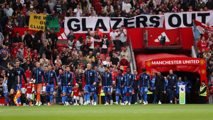 MANCHESTER, ENGLAND - SEPTEMBER 16: Players of both side's enter the pitch as fans of Manchester United hold a banner which reads 'Glazers Out' prior to the Premier League match between Manchester United and Brighton & Hove Albion at Old Trafford on September 16, 2023 in Manchester, England. (Photo by Lewis Storey/Getty Images) Manchester, i tifosi Red Devils non vogliono più ten Hag: e allora cantano “Viva Ronaldo”… - immagine 1