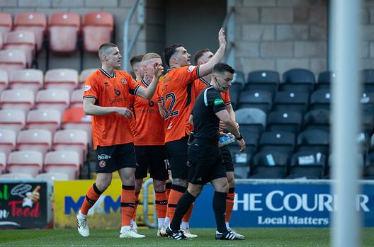 Tony Watt del Dundee United raccoglie una bottiglia di vetro lanciata dai tifosi del Raith Rovers mentre festeggia dopo aver segnato il gol del vantaggio di 1-0 durante una partita decisiva del campionato tra Dundee United e Raith Rovers al Tannadice Park, il 30 marzo 2024, a Dundee Dilettanti, campo squalificato per lancio di panini e ossa di bistecche- immagine 3