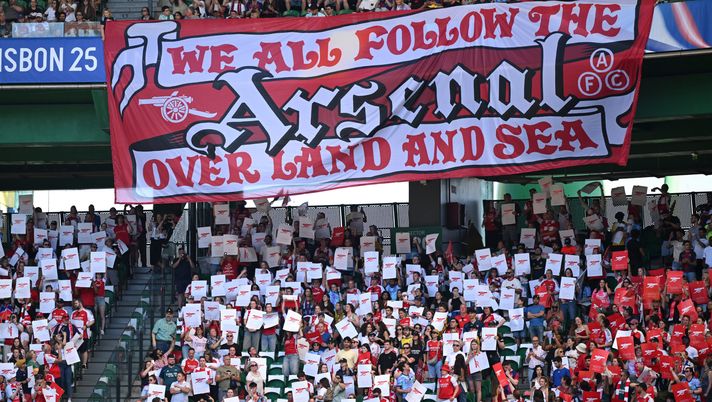 LISBON, PORTUGAL - MAY 24: Fans of Arsenal display a banner which reads 'We all follow the Arsenal over land and sea' prior to the UEFA Women's Champions League final match between Arsenal WFC and FC Barcelona at Estadio Jose Alvalade on May 24, 2025 in Lisbon, Portugal. (Photo by David Ramos/Getty Images) L’ex talento dell’Arsenal Billy Vigar in coma farmacologico dopo un infortunio in campo - immagine 1