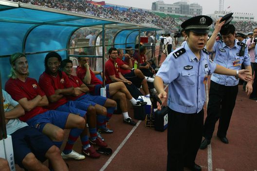 Maxi Lopez e Ronaldinho sorridono mentre guardano i poliziotti cinesi disperdere i fotografi che circondano i giocatori del Barcellona prima di una partita amichevole contro il Beijing Guoan il 5 agosto 2007 a Pechino. (Foto di Andrew Wong/Getty Images) Maxi Lopez, le notti folli a Barcellona e l’ultimatum dell’ex: “Scegli, o me o Ronaldinho- immagine 2