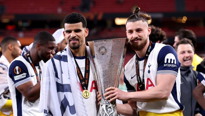 BILBAO, SPAIN - MAY 21: Dominic Solanke and Radu Dragusin of Tottenham Hotspur pose for a photograph with the UEFA Europa League trophy after their team's victory in the UEFA Europa League Final 2025 between Tottenham Hotspur and Manchester United at Estadio de San Mames on May 21, 2025 in Bilbao, Spain. (Photo by Michael Steele/Getty Images) Tottenham, tre giocatori senza medaglie: il comunicato di scuse della UEFA - immagine 1