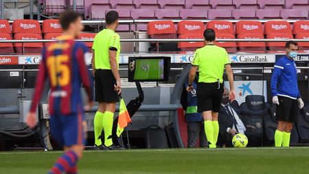 BARCELONA, SPAIN - OCTOBER 24: Referee Juan Martinez Munuera uses the pitch side monitor to complete a VAR review before awarding Real Madrid a penalty during the La Liga Santander match between FC Barcelona and Real Madrid at Camp Nou on October 24, 2020 in Barcelona, Spain. Sporting stadiums around Spain remain under strict restrictions due to the Coronavirus Pandemic as Government social distancing laws prohibit fans inside venues resulting in games being played behind closed doors. (Photo by Alex Caparros/Getty Images)