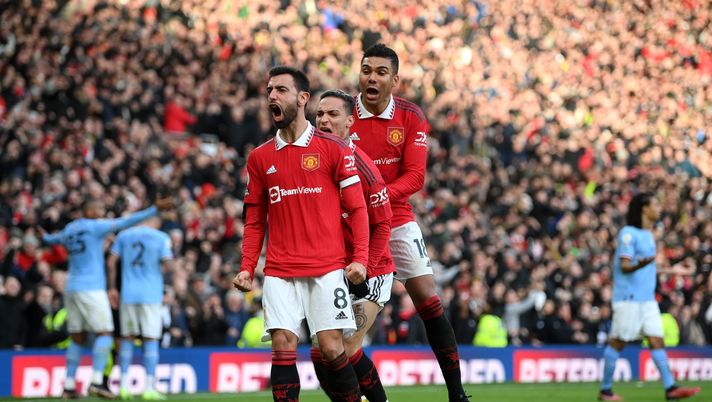 MANCHESTER, ENGLAND - JANUARY 14: Bruno Fernandes of Manchester United celebrates with team mates Antony and Casemiro after scoring the team's first goal during the Premier League match between Manchester United and Manchester City at Old Trafford on January 14, 2023 in Manchester, England. (Photo by Shaun Botterill/Getty Images) Champions League