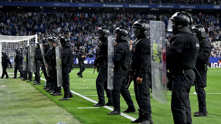 BARCELONA, SPAIN - MAY 15: Riot police officers observe fans from the touchline following Barcelona's victory and confirmation of winning the LaLiga title after the LaLiga match between RCD Espanyol de Barcelona and FC Barcelona at RCDE Stadium on May 15, 2025 in Barcelona, Spain. (Photo by David Ramos/Getty Images) Málaga-Deportivo La Coruña, la polizia arresta un narcotrafficante nel traffico post-partita - immagine 1