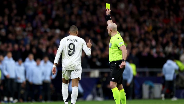 MADRID, SPAIN - MARCH 12: Referee Szymon Marciniak shows a yellow card to Kylian Mbappe of Real Madrid during the penalty shootout during the UEFA Champions League 2024/25 Round of 16 second leg match between Atletico de Madrid and Real Madrid C.F. at Estadio Metropolitano on March 12, 2025 in Madrid, Spain. (Photo by Florencia Tan Jun/Getty Images) UEFA, arrivano le dure sanzioni per Mbappè, Rudiger e Ceballos: la situazione - immagine 1