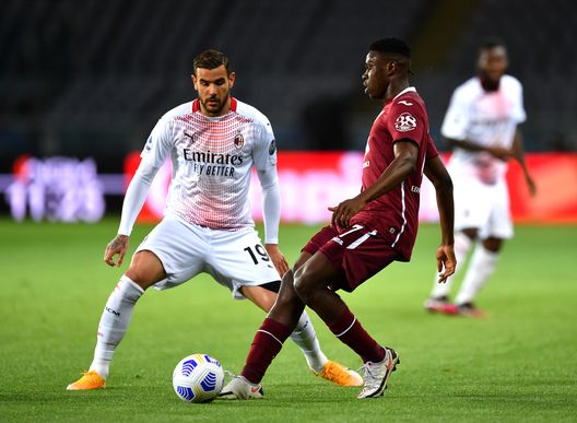 TURIN, ITALY - MAY 12: Wilfried Singo of Torino FC makes a pass whilst under pressure from Theo Hernandez of A.C. Milan during the Serie A match between Torino FC and AC Milan at Stadio Olimpico di Torino on May 12, 2021 in Turin, Italy. Sporting stadiums around Italy remain under strict restrictions due to the Coronavirus Pandemic as Government social distancing laws prohibit fans inside venues resulting in games being played behind closed doors. (Photo by Valerio Pennicino/Getty Images)
