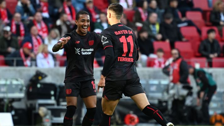 MAINZ, GERMANY - OCTOBER 18: Martin Terrier of Leverkusen celebrates scoring his team's fourth goal with Arthur during the Bundesliga match between 1. FSV Mainz 05 and Bayer 04 Leverkusen at MEWA Arena on October 18, 2025 in Mainz, Germany. (Photo by Neil Baynes/Getty Images) Lipsia-Leverkusen: dove vederla in diretta tv e streaming, probabili formazioni - immagine 1