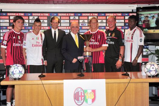 (Da sinistra) L'attaccante dell'AC Milan Alberto Paloschi, l'attaccante Stephan El Shaarawy, l'allenatore Massimiliano Allegri, il vicepresidente Adriano Galliani, il capitano Massimo Ambrosini, il difensore Philippe Mexes e il difensore Taye Taiwo della Nigeria posano con lo scudetto vinto la stagione precedente durante una presentazione al Milanello Training Center di Carnago, vicino a Varese, il 12 luglio 2011 Silvio Berlusconi, gli anni d’oro del Milan e la Serie A col Monza- immagine 6